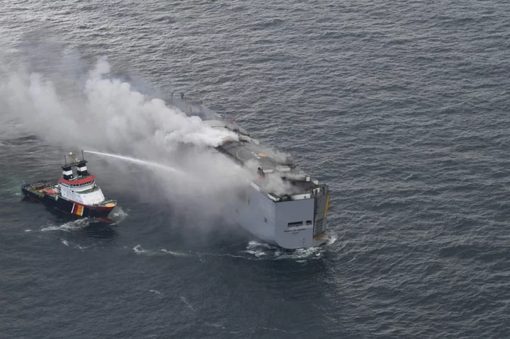 Fire on ship carrying 3,000 cars burns out of control and kills crew member